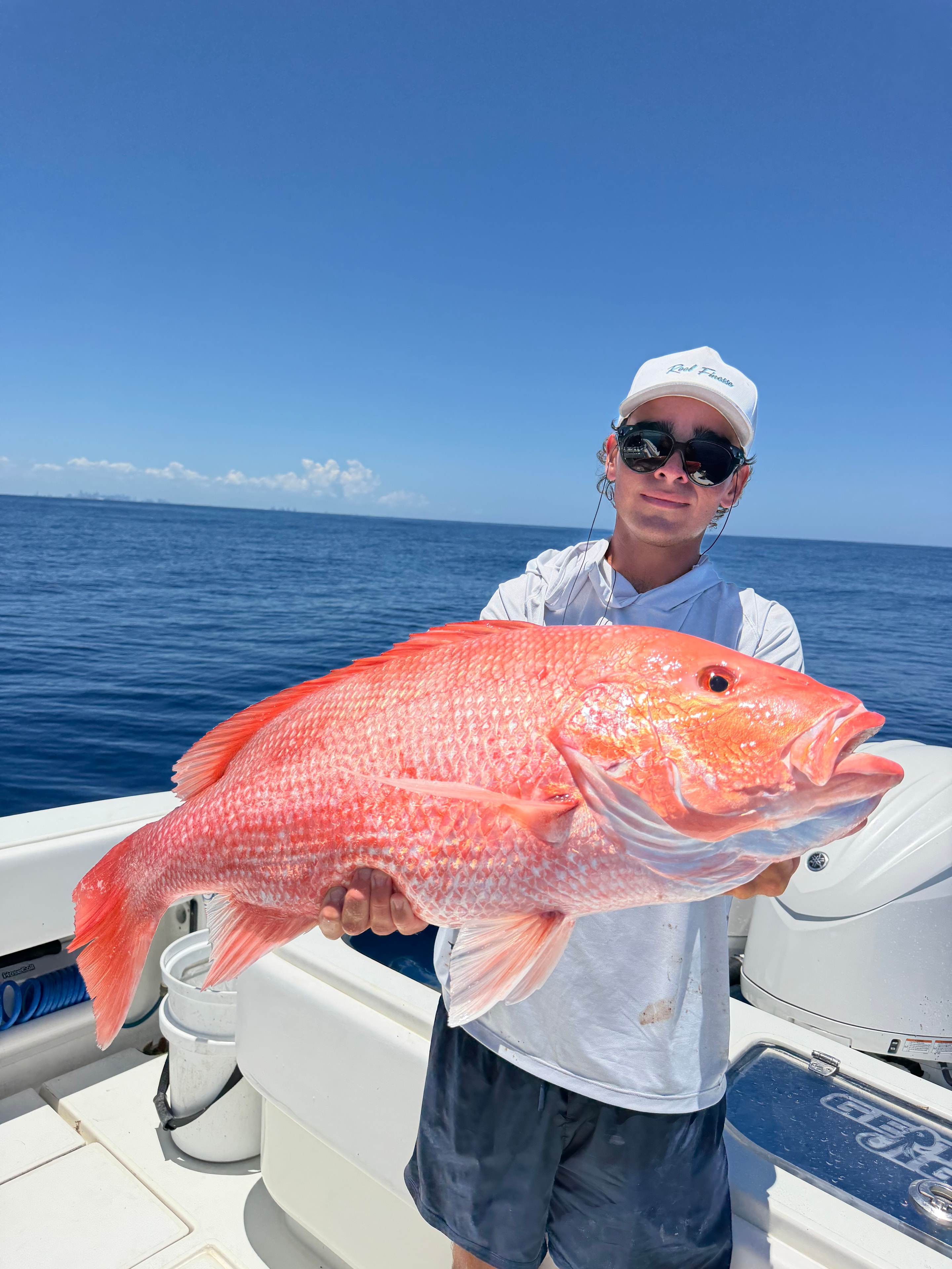 Angler holding a large red snapper caught bottom fishing off Miami